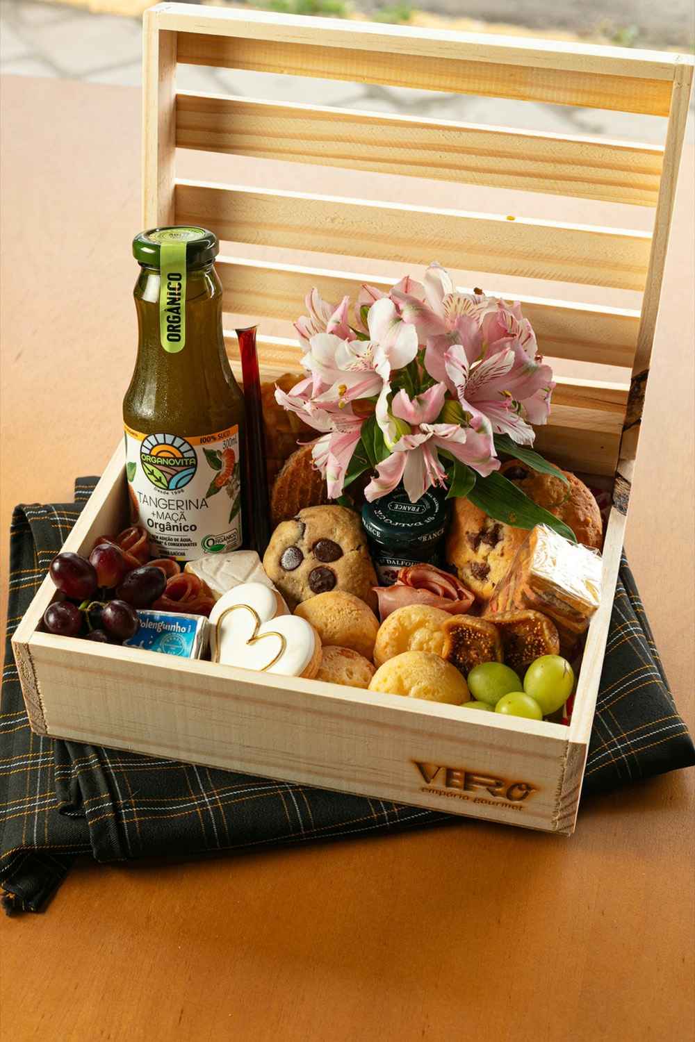 An elegant gourmet gift crate with pastries, fresh fruit, and flowers
